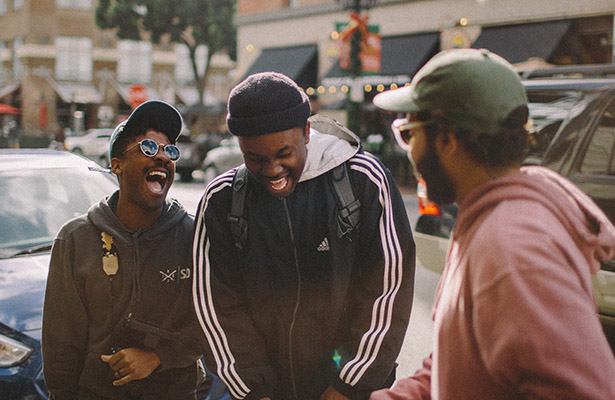 photo three young men in jacket laughing at each other