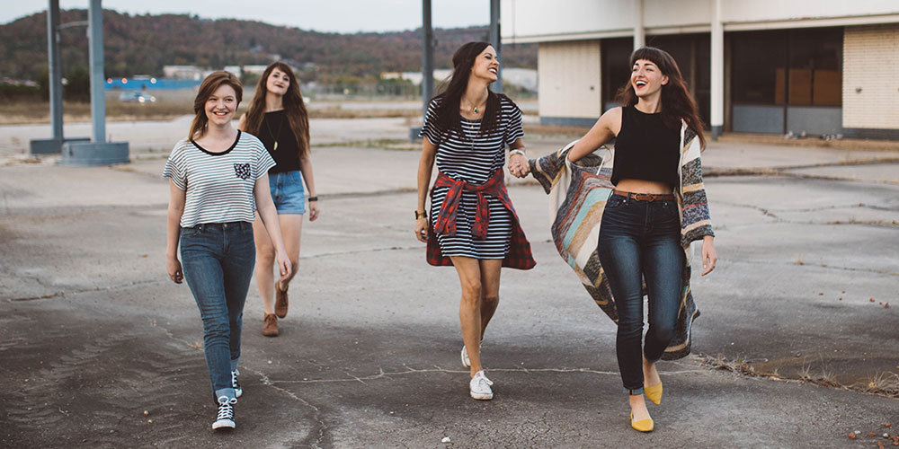 photo of four girls walking near warehouse