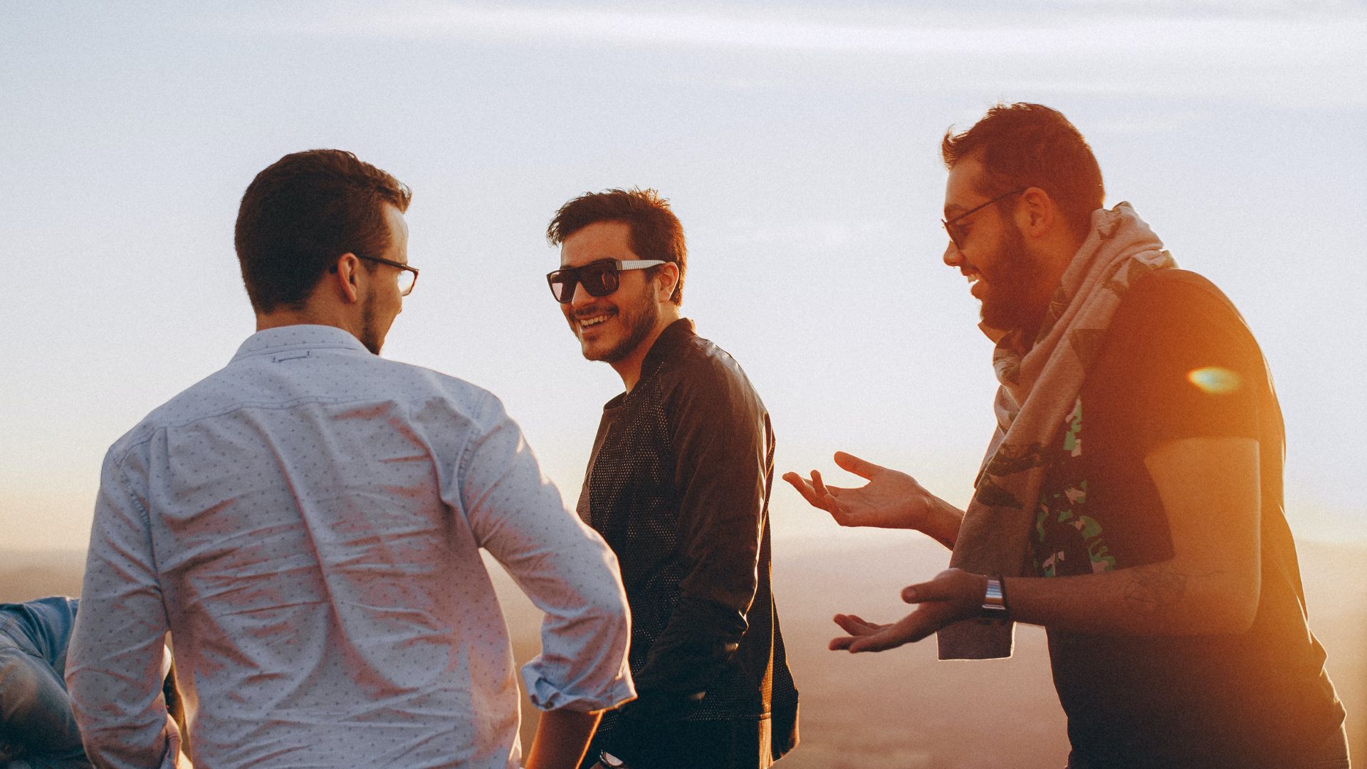 three men standing while laughing