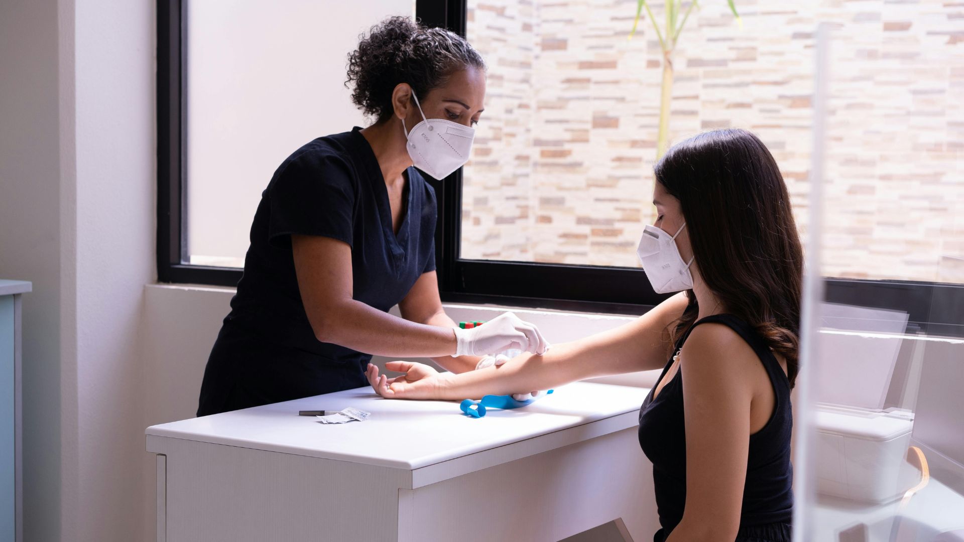 nurse wiping the arm of a patient after blood test