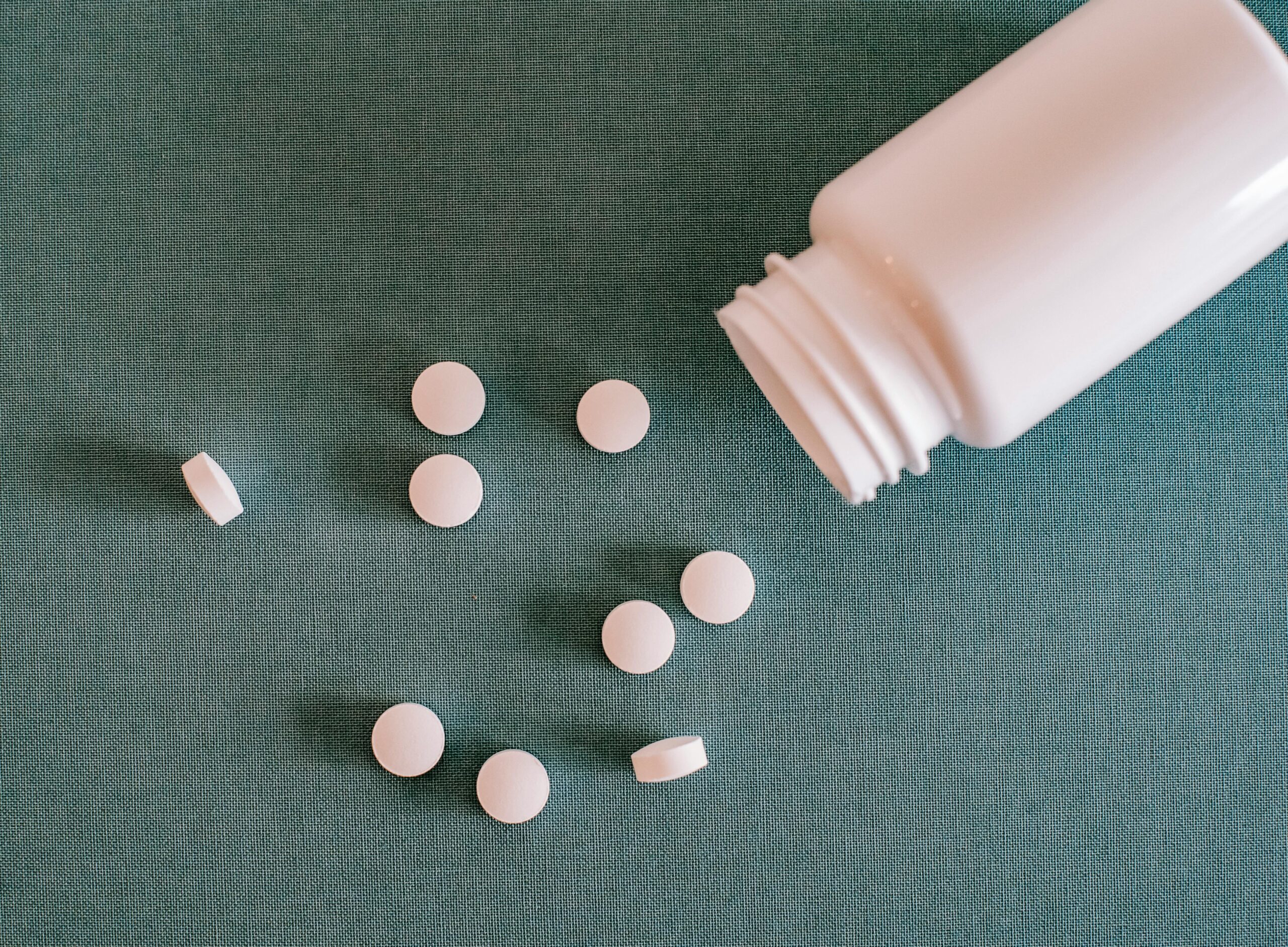 a white tablet spill from bottle