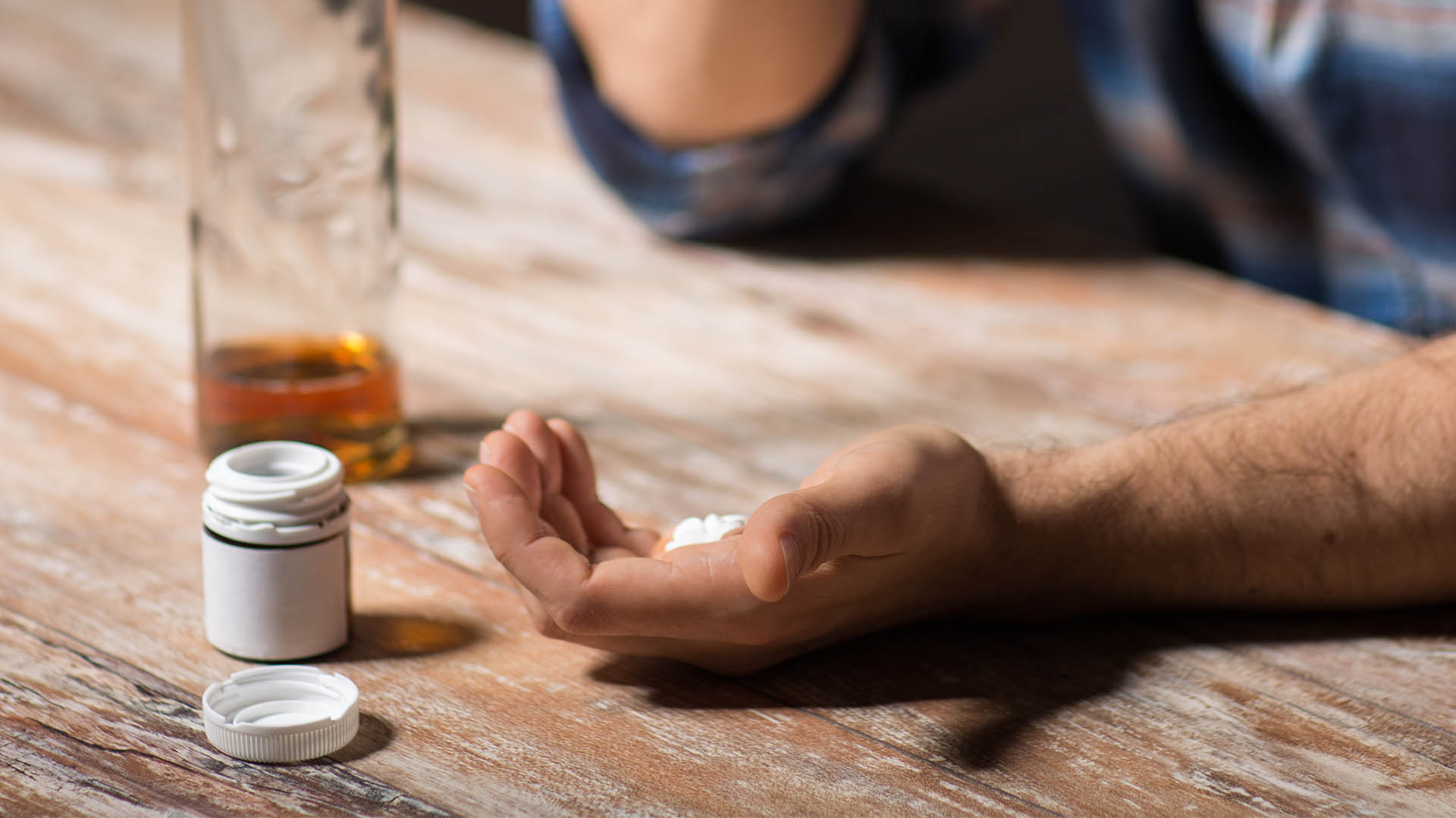 drunk man with bottle of alcohol and pills