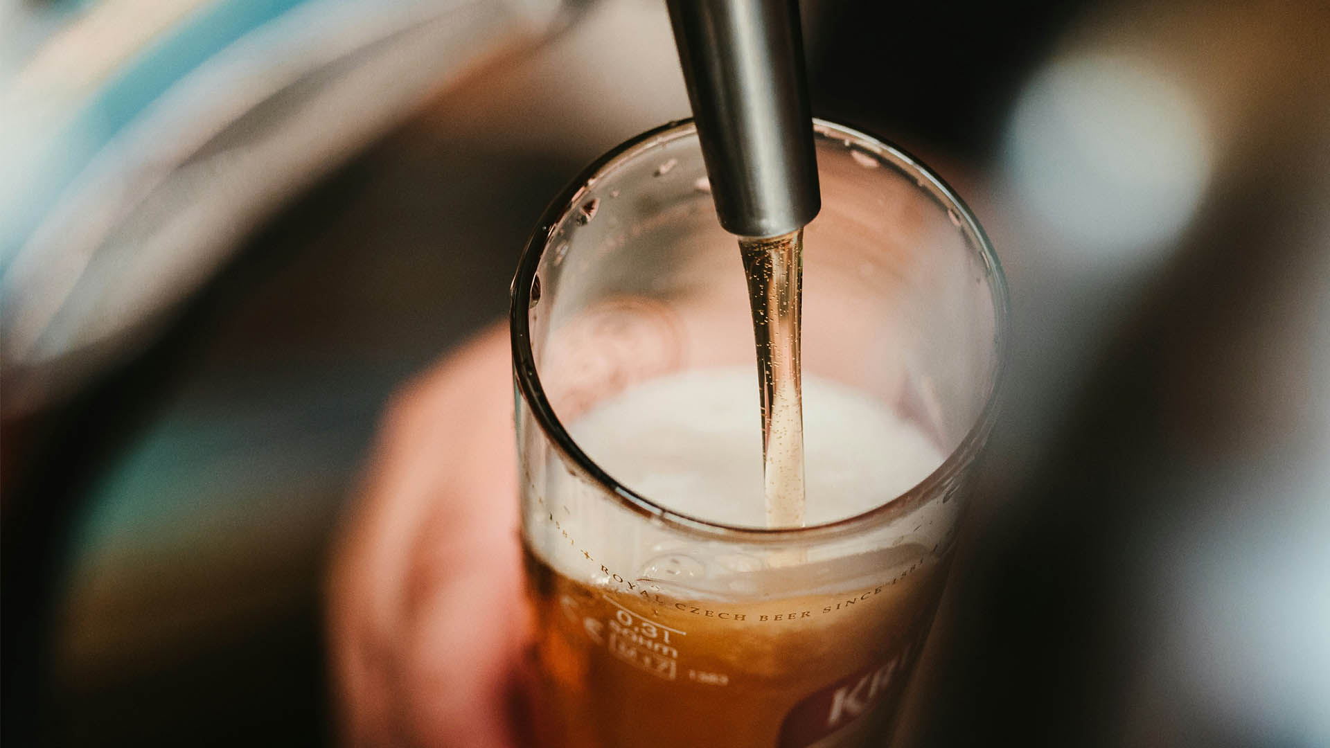 person filling clear glass with alcohol