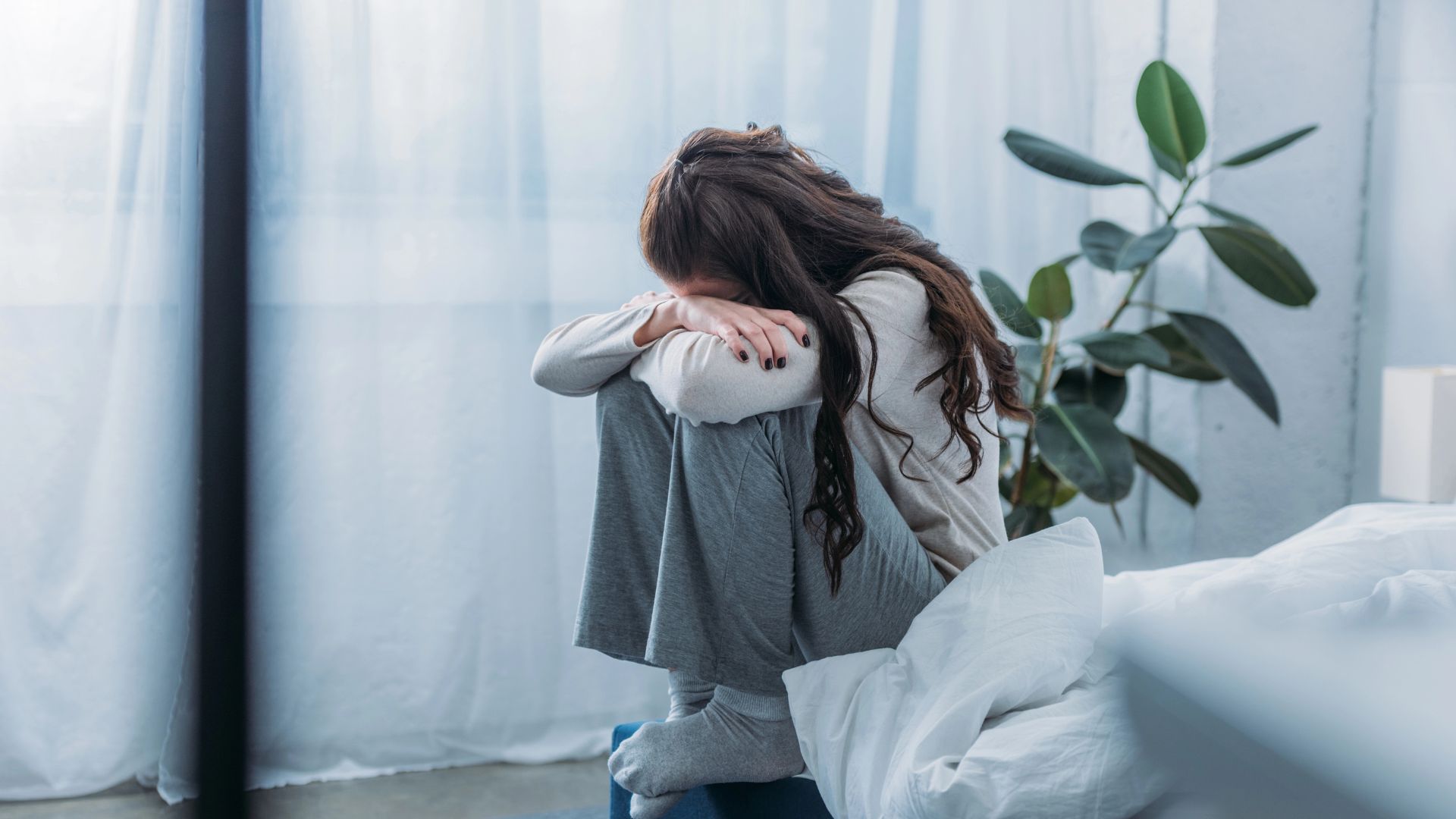 woman sitting covering face hands