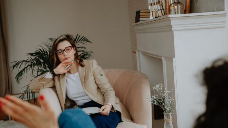 A woman counselor attentively listens during a therapy session