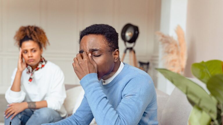 Man in blue sweater looking distressed during a therapy session