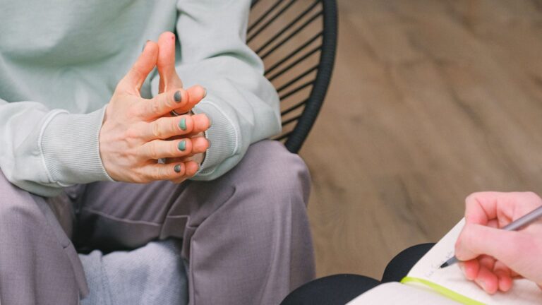 therapy session showing hands and a notepad